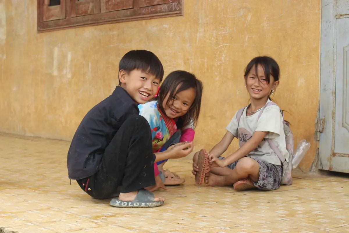 Ba em nhỏ cùng vui chơi trước hiên nhà